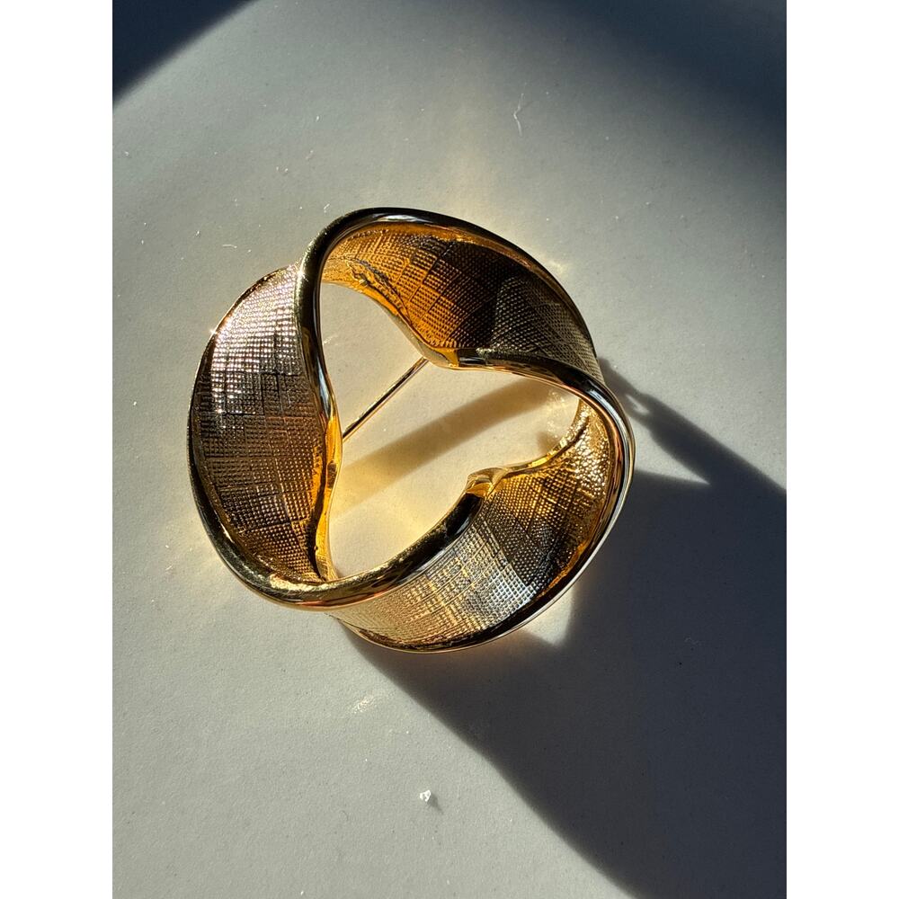 Napier gold ribbon twist circle brooch